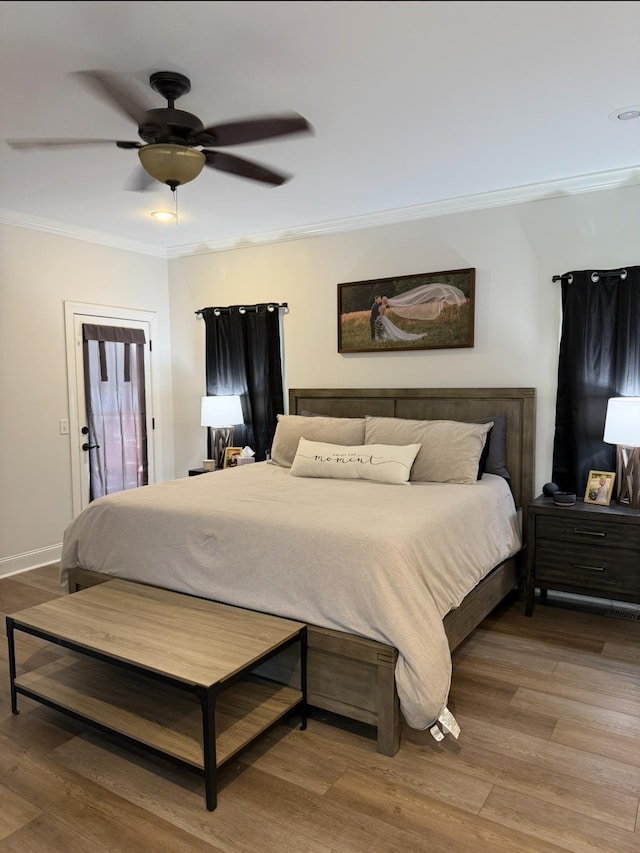 bedroom with baseboards, a ceiling fan, crown molding, and wood finished floors