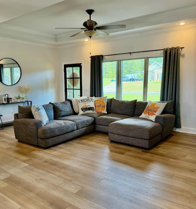 living area with crown molding, ceiling fan, light wood finished floors, and a healthy amount of sunlight