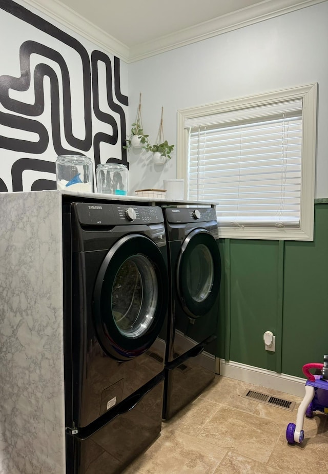 clothes washing area with laundry area, ornamental molding, washing machine and dryer, and visible vents