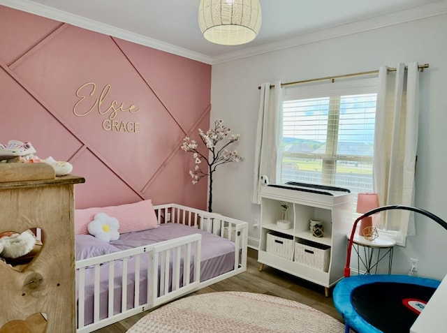 bedroom with crown molding, baseboards, and wood finished floors