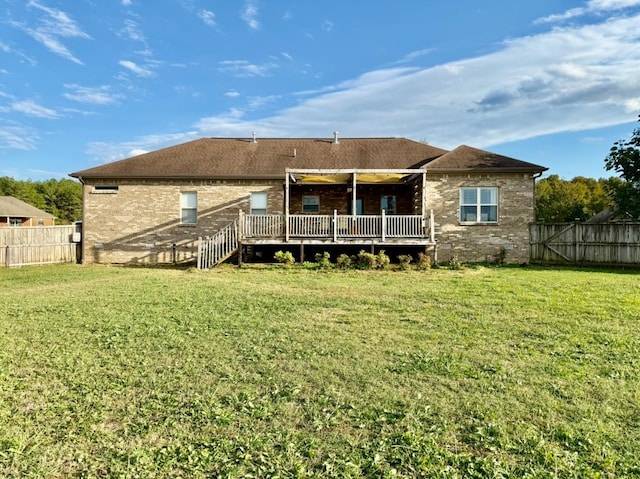 rear view of house with a yard, brick siding, fence private yard, and a wooden deck