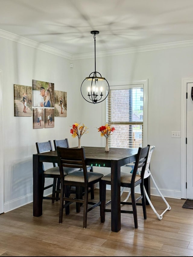 dining area featuring baseboards, ornamental molding, and wood finished floors