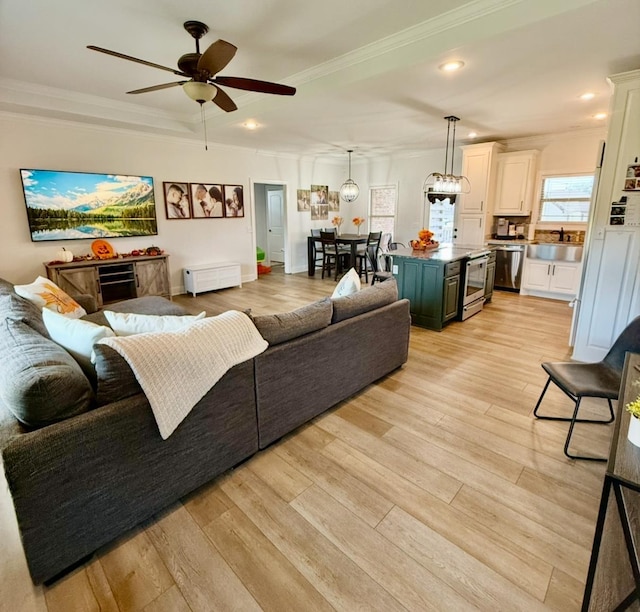 living room with light wood-style floors, ceiling fan, ornamental molding, and recessed lighting