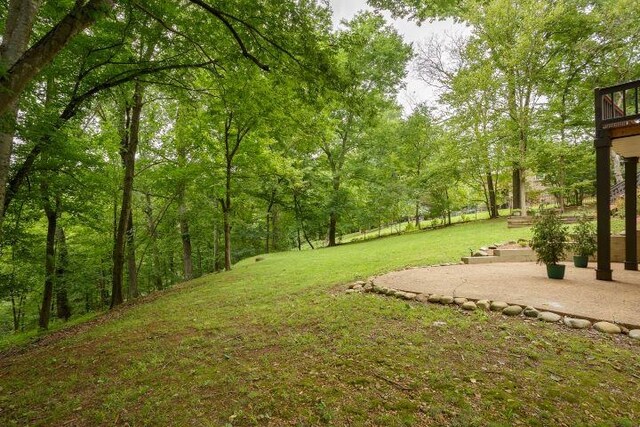  - view of green lawn featuring a patio