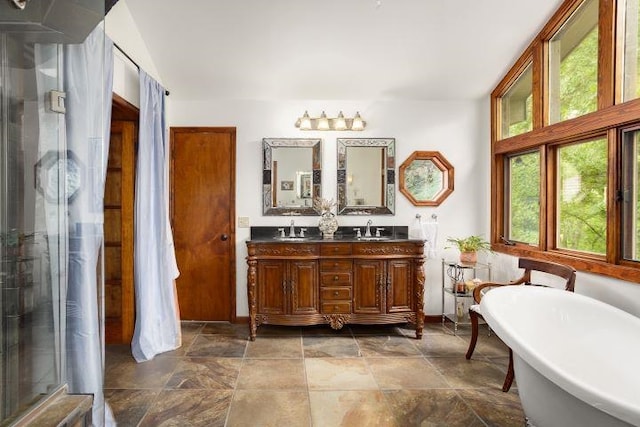  - full bathroom featuring double vanity, a shower stall, a soaking tub, and stone finish floors