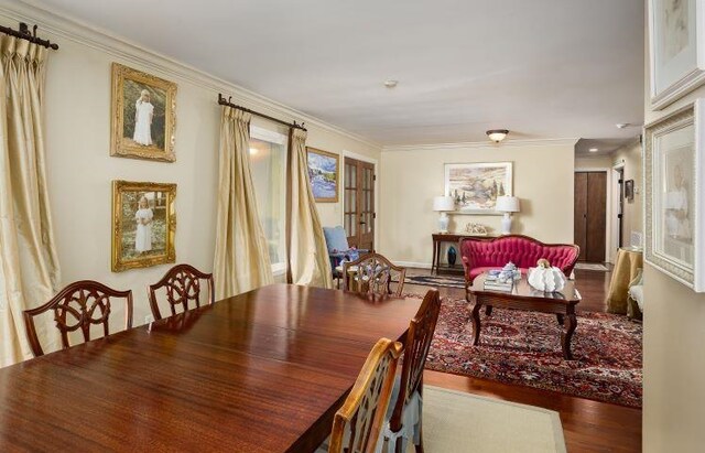  - dining room featuring wood finished floors and ornamental molding