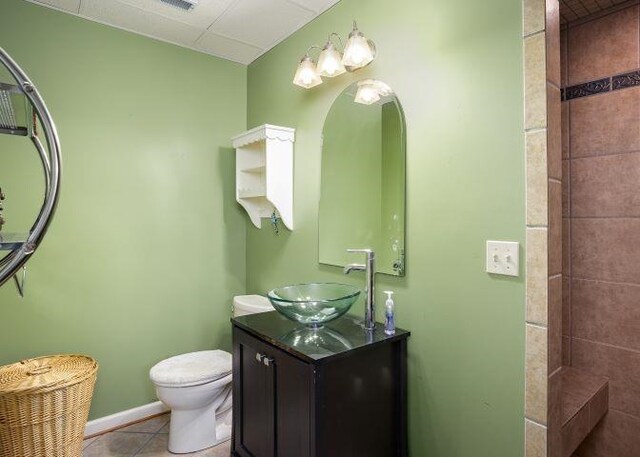  - bathroom featuring tile patterned flooring, vanity, and tiled shower