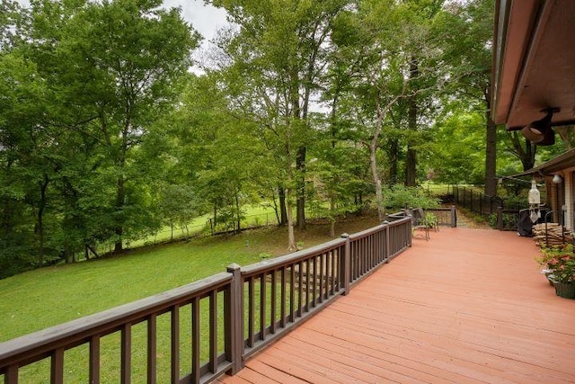  - wooden deck featuring a lawn and view of scattered trees