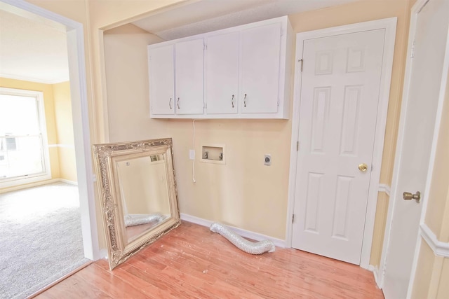 washroom with cabinets, hookup for a washing machine, hookup for an electric dryer, and light wood-type flooring