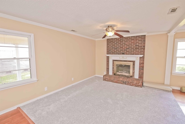 unfurnished living room featuring crown molding, a brick fireplace, and a wealth of natural light