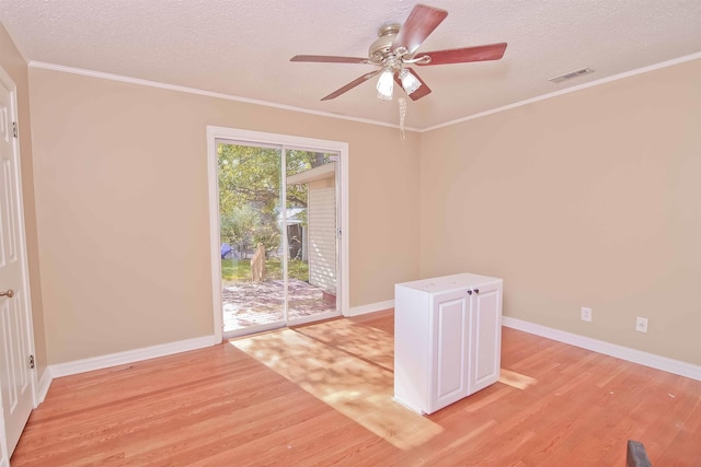 unfurnished room featuring ornamental molding, a textured ceiling, and light wood-type flooring