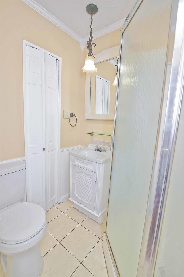 bathroom featuring walk in shower, toilet, ornamental molding, vanity, and tile patterned flooring