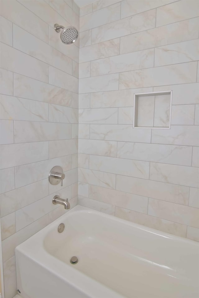 bathroom featuring tiled shower / bath