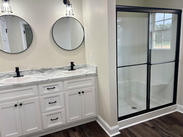 bathroom with hardwood / wood-style flooring, vanity, and a shower with shower door