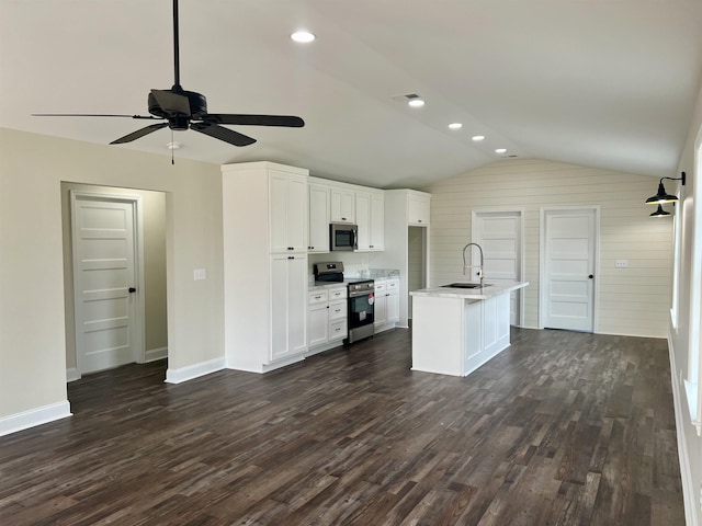 kitchen with sink, dark hardwood / wood-style flooring, an island with sink, white cabinets, and appliances with stainless steel finishes