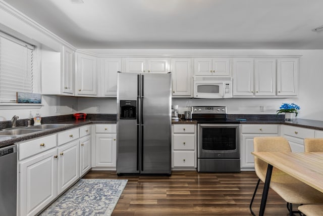 kitchen featuring white cabinetry, dark wood-type flooring, stainless steel appliances, and sink