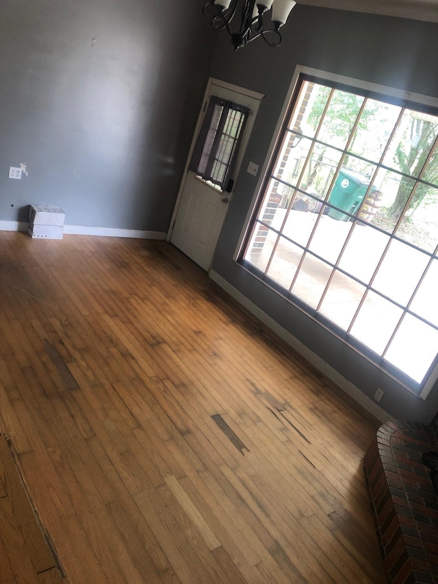 unfurnished room with a chandelier and hardwood / wood-style flooring