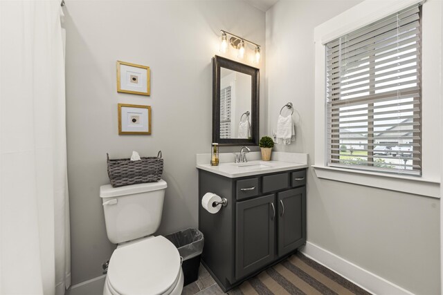  - bathroom featuring vanity, toilet, and baseboards