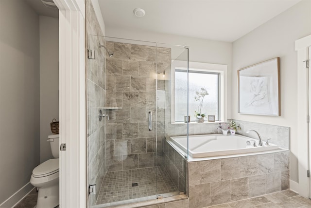  - full bathroom featuring a garden tub, toilet, a shower stall, and baseboards