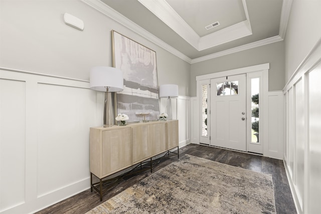  - entrance foyer featuring a decorative wall, dark wood-style flooring, a wainscoted wall, ornamental molding, and a raised ceiling