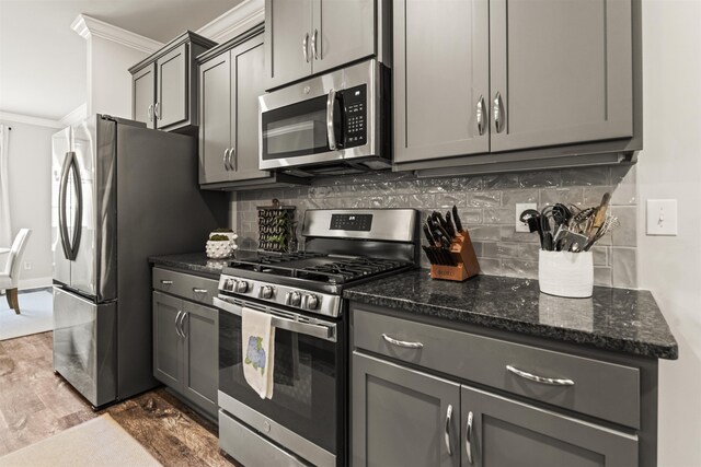  - kitchen with stainless steel appliances, ornamental molding, gray cabinets, and dark wood-style flooring