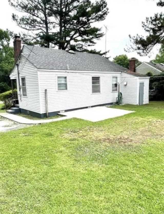 rear view of house with a lawn and a patio