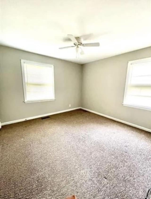 empty room with ceiling fan and carpet