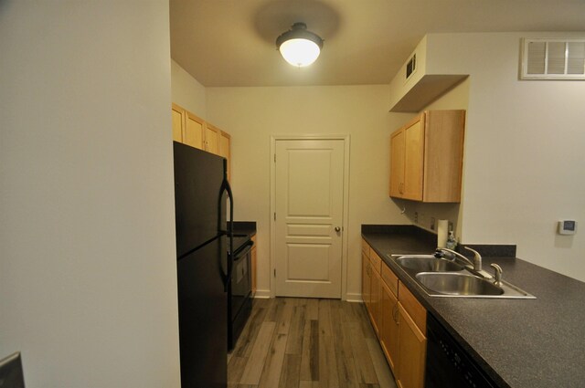 kitchen featuring a sink, visible vents, dark countertops, and black appliances