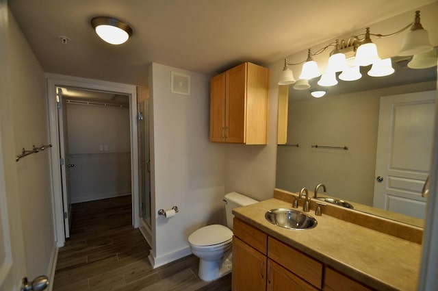 bathroom with visible vents, toilet, a stall shower, wood finished floors, and baseboards