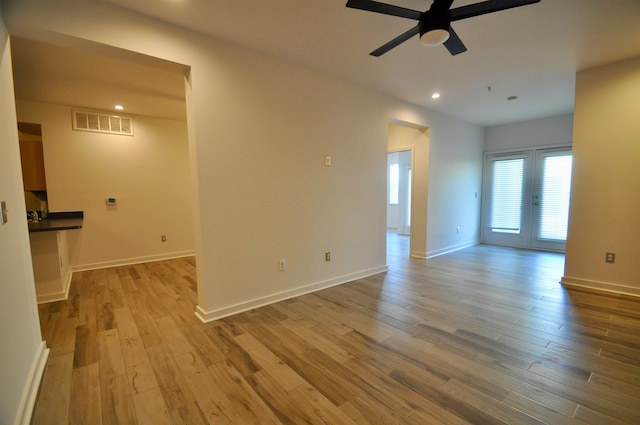 empty room with baseboards, wood finished floors, visible vents, and ceiling fan