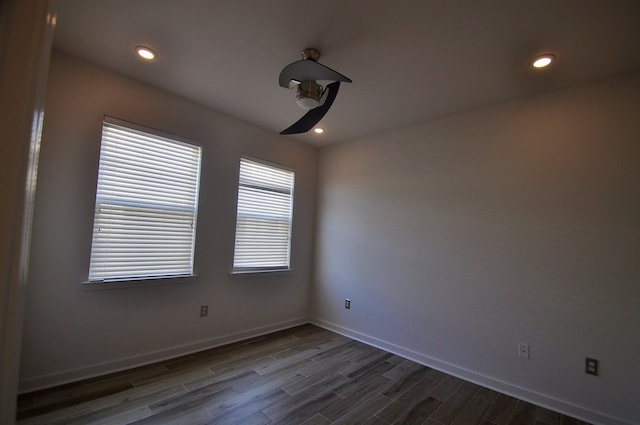 empty room with recessed lighting, baseboards, and dark wood-style flooring