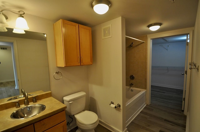 full bath featuring visible vents, baseboards, toilet, wood finished floors, and  shower combination