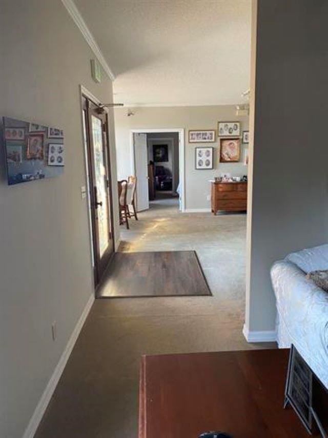  - corridor featuring baseboards, crown molding, carpet, and lofted ceiling