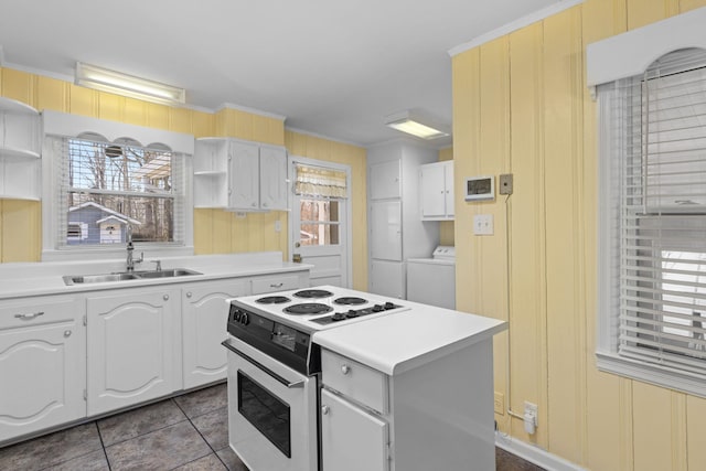 kitchen featuring open shelves, washer / clothes dryer, light countertops, white electric range, and a sink