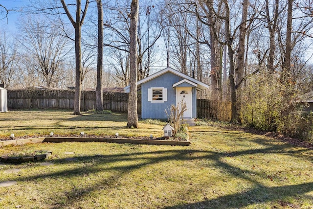 view of yard with a storage unit, fence, and an outbuilding