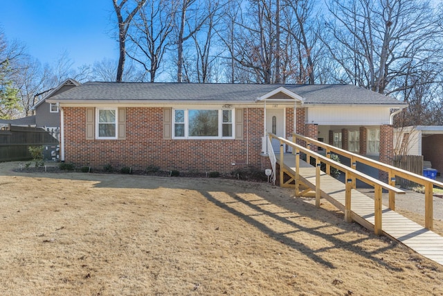 single story home featuring a shingled roof, brick siding, and fence