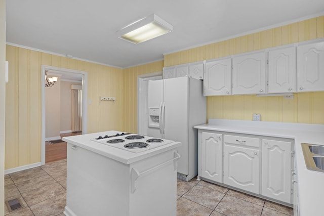 kitchen featuring white appliances, white cabinets, crown molding, and light tile patterned flooring