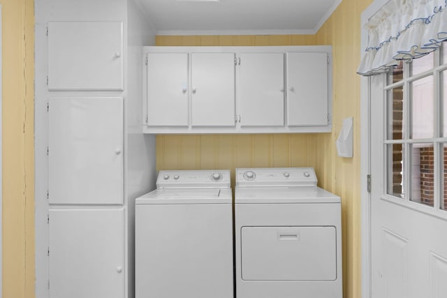 laundry area with washing machine and dryer, cabinet space, and crown molding