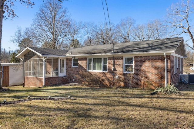 exterior space featuring a sunroom, a lawn, and brick siding