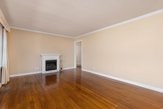 unfurnished living room with visible vents, baseboards, a glass covered fireplace, hardwood / wood-style flooring, and crown molding