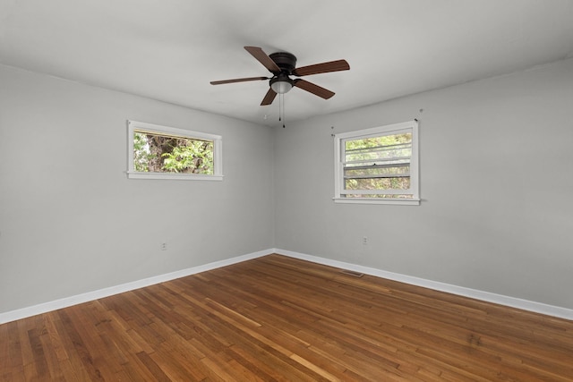 unfurnished room with baseboards, plenty of natural light, and wood finished floors