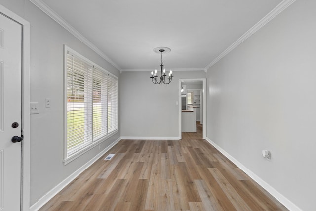 unfurnished dining area featuring a chandelier, ornamental molding, light wood finished floors, and baseboards