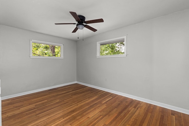 unfurnished room with baseboards, healthy amount of natural light, and wood finished floors