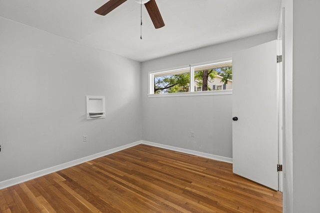 spare room featuring ceiling fan, wood finished floors, and baseboards