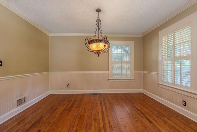  - unfurnished room featuring wood finished floors, a chandelier, a textured ceiling, ornamental molding, and a wainscoted wall