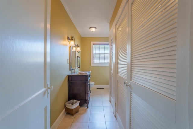  - hallway featuring ornamental molding, light tile patterned floors, and baseboards