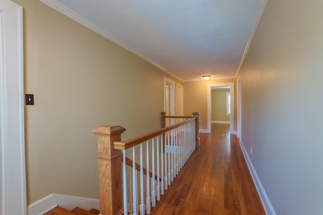  - corridor with an upstairs landing, ornamental molding, wood finished floors, and baseboards