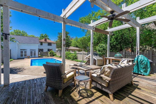  - view of pool with french doors, a wooden deck, and a fenced backyard