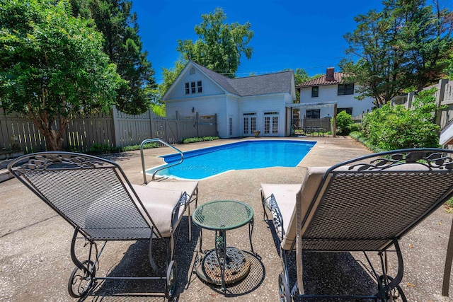  - view of swimming pool featuring french doors, a patio area, a storage structure, and an outdoor structure