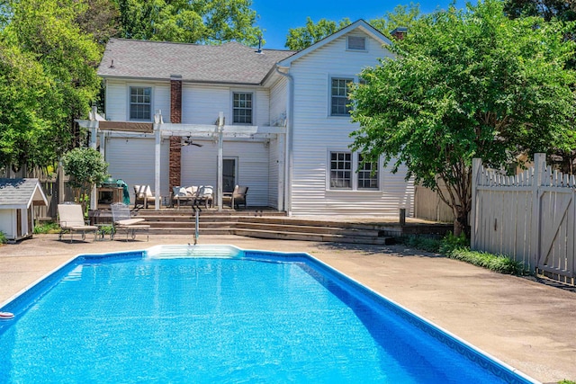  - rear view of property featuring a pergola, a wooden deck, a patio area, and a shingled roof